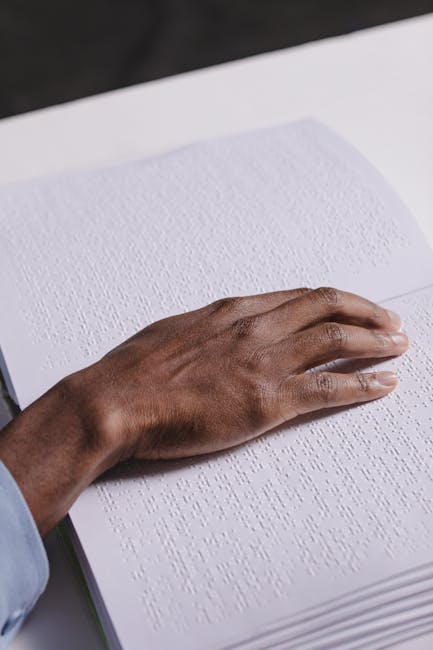 Mano che legge un libro in braille, simbolo di inclusione educativa e accessibilità per studenti con disabilità visive.