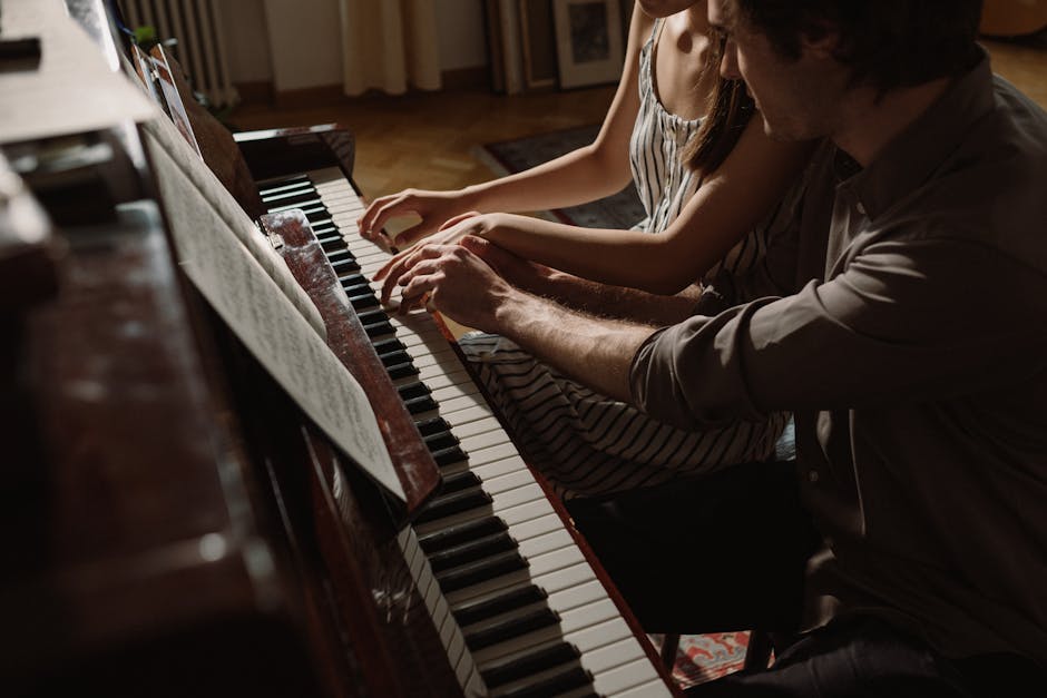 Lezione di pianoforte con tutor: mani di studente e insegnante sui tasti per apprendere la tecnica musicale e sviluppare il talento.