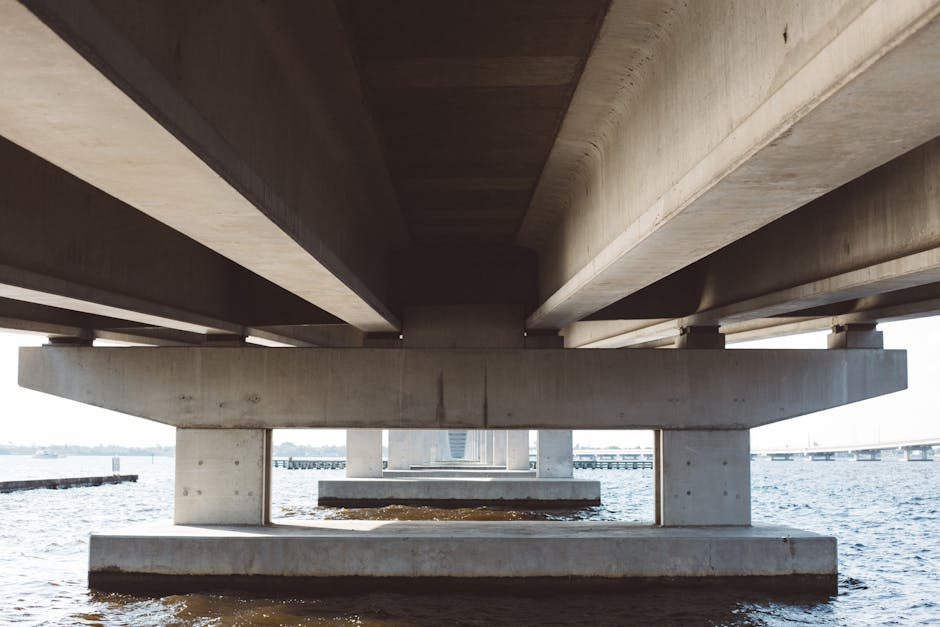 Struttura di un ponte in cemento sull'acqua, metafora di connessione tra insegnante curricolare e di sostegno con piattaforme AI.