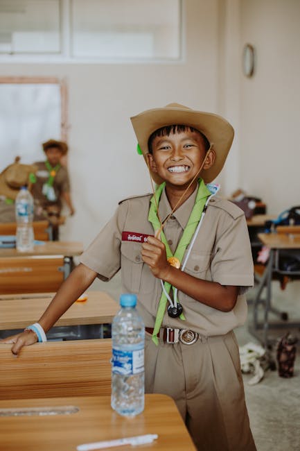 Studente sorridente in uniforme scout in aula, preparazione al concorso scuola 2025 primaria e secondaria