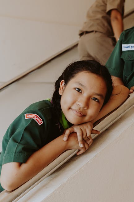 Ragazza sorridente in uniforme scout, sviluppo sociale infantile e importanza dell'unicità nel percorso di crescita personale e collettiva.