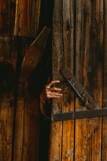 Mano che spunta da una porta di legno: metafora di segreti e irregolarità nascoste nei processi e nei comportamenti.