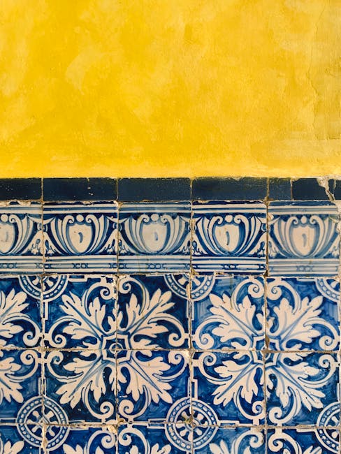 Muro giallo con piastrelle blu e bianche simmetriche, concetto di asse di simmetria nei triangoli e geometria visiva