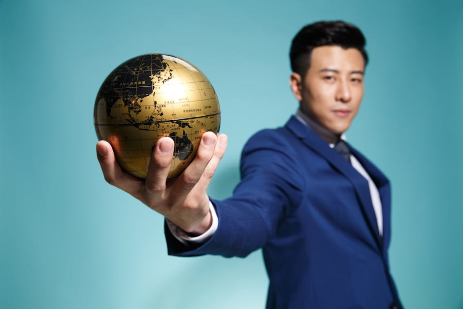 Uomo d'affari con mappamondo dorato: strategie per la crescita economica globale nel mondo moderno e sviluppo sostenibile