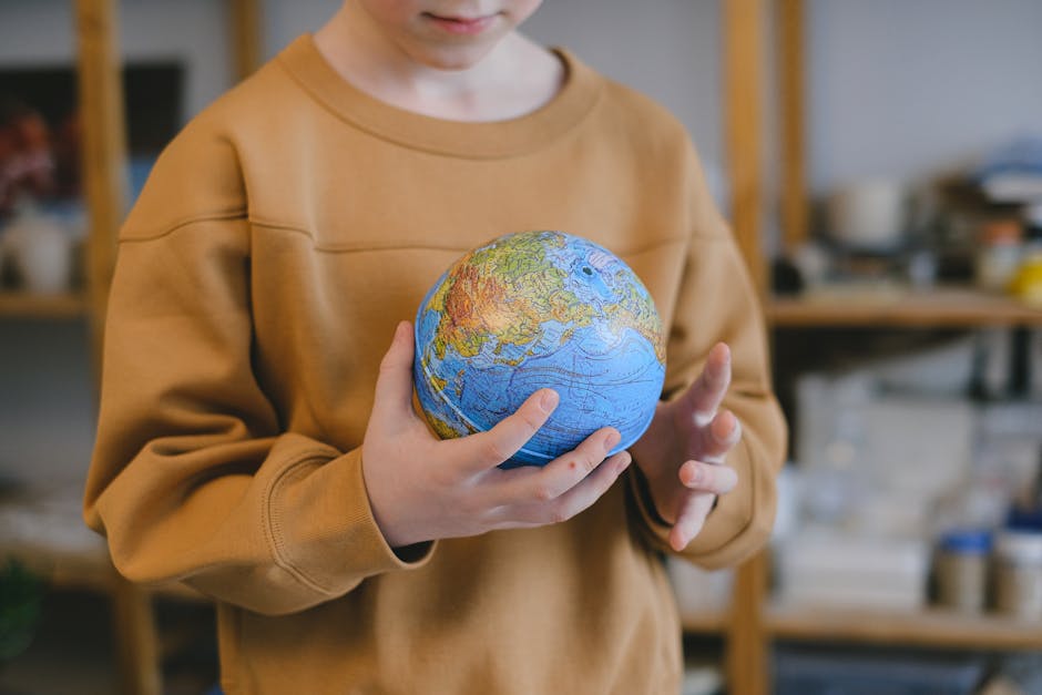 Bambino che tiene in mano un mappamondo, simbolo di apprendimento globale e adattamento culturale nelle metodologie didattiche inclusive.