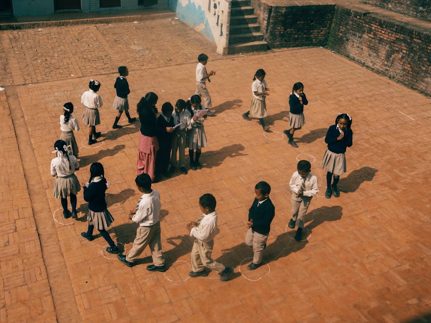 Bambini in cerchio durante lezione di educazione motoria nella scuola primaria, focus sulla tutela dell'organico dei docenti.