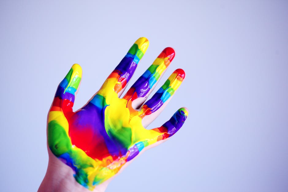 Mano di bambino dipinta con colori arcobaleno, simbolo di creatività e espressione artistica unica nell'infanzia. Favorire la creatività nei bambini.