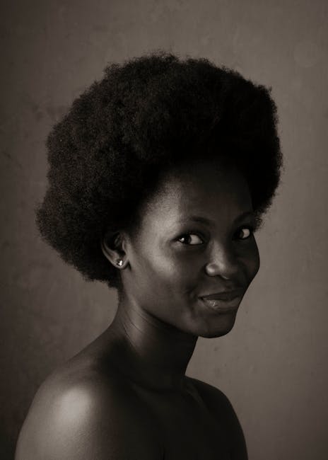 Ritratto in bianco e nero di donna afro con capelli afro, espressione serena, simbolo di identità e valori unici.