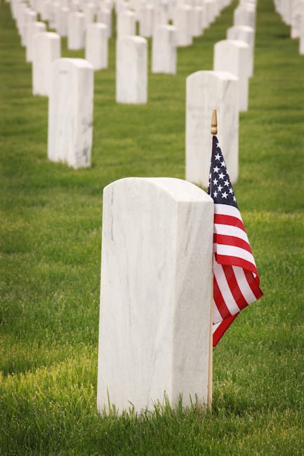 Cimitero militare americano con lapidi bianche e bandiera USA, simbolo di eroismo e sacrificio nel nobile turno.