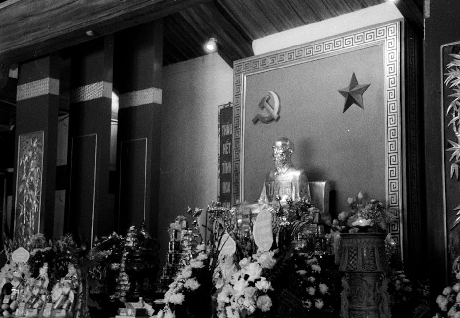Statua di Ho Chi Minh con simboli comunisti, eredità politica e spirituale del leader vietnamita, analisi storica e culturale.