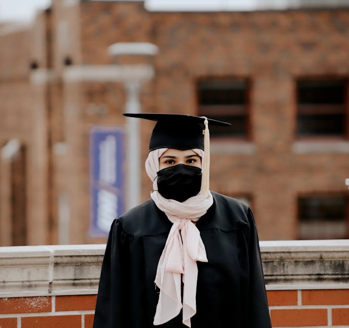 Studentessa laureata con mascherina, simbolo di resilienza e adattamento nel sistema scolastico post-pandemia e prove Invalsi AI.