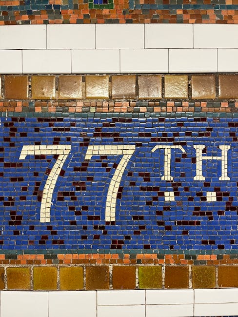 Mosaico artistico con indicazione '77th' in una stazione della metropolitana americana, simbolo della diversità culturale.