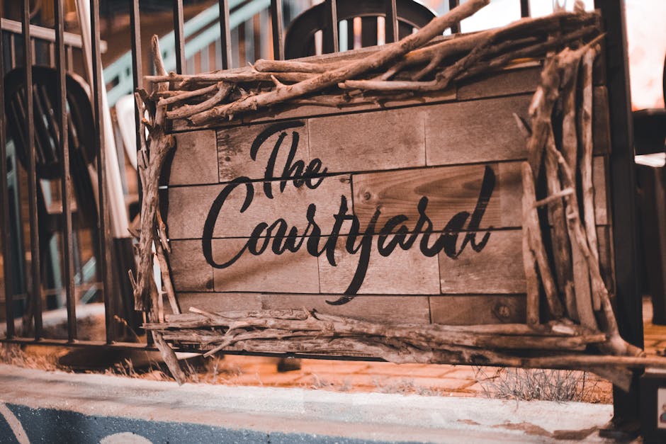 Insegna in legno The Courtyard decorata con rami, esempio di ambiente di apprendimento unico e distintivo.