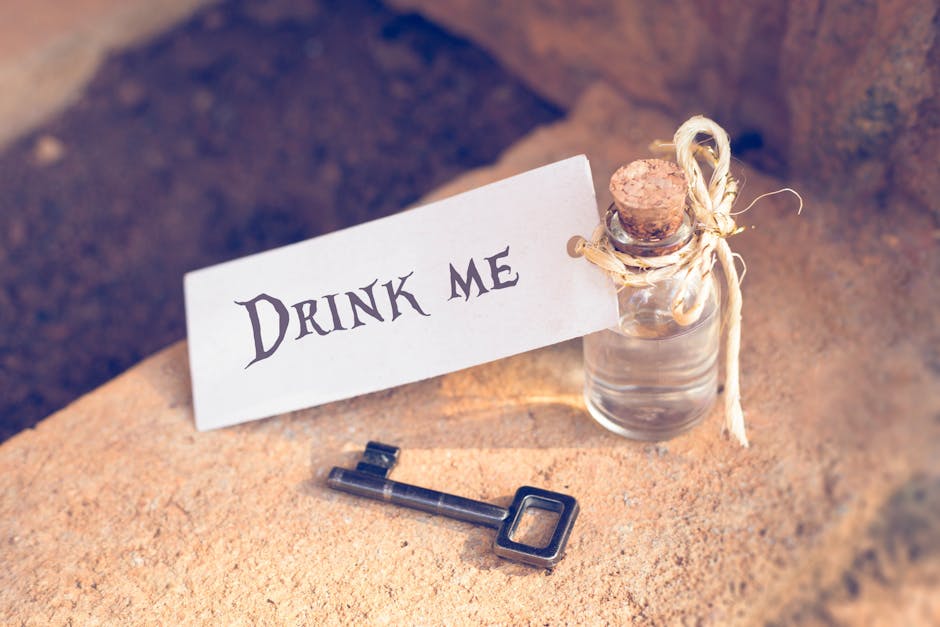 Bottiglia con etichetta 'Drink Me' e chiave, ispirazione Alice nel Paese delle Meraviglie per articolo su misteri e magie del libro.