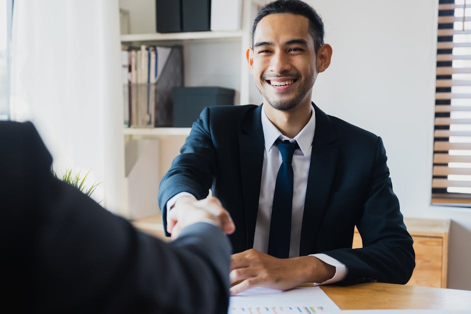 Uomo sorridente stringe la mano a un collega, simbolo di collaborazione e successo nell'educazione degli adulti e nelle metodologie didattiche.