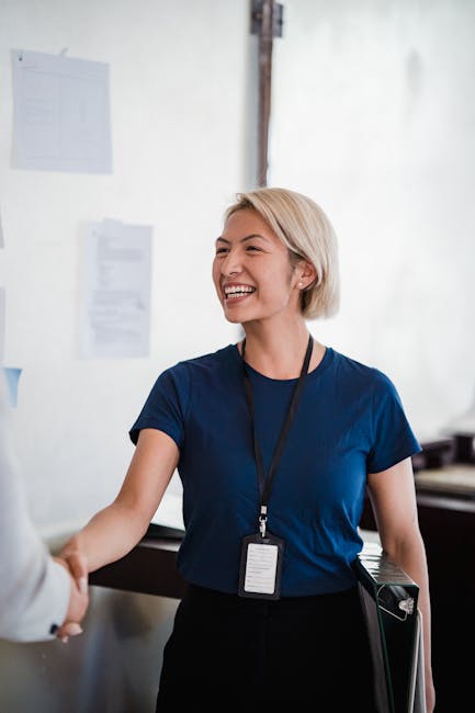 Docente sorridente stringe la mano a un membro dello staff di direzione, simbolo di collaborazione e gestione delle tensioni scolastiche.