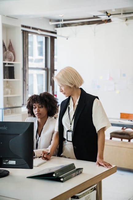 Due donne collaborano a un progetto tecnologico, promuovendo l'inclusione digitale e l'innovazione nel mondo del lavoro moderno.