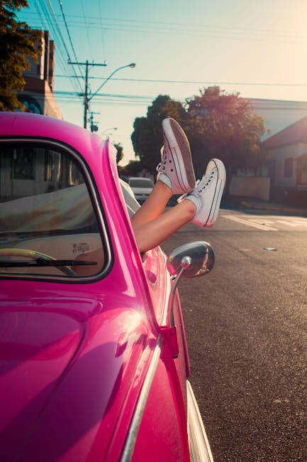 Piedi fuori dal finestrino di una Fiat 500 rosa, conversione piedi in centimetri per calcolare l'altezza della persona