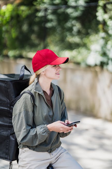 Ragazza con cappellino rosso e zaino termico consulta il GPS sullo smartphone per servizio di sostegno senza titolo, valutabilità e novità