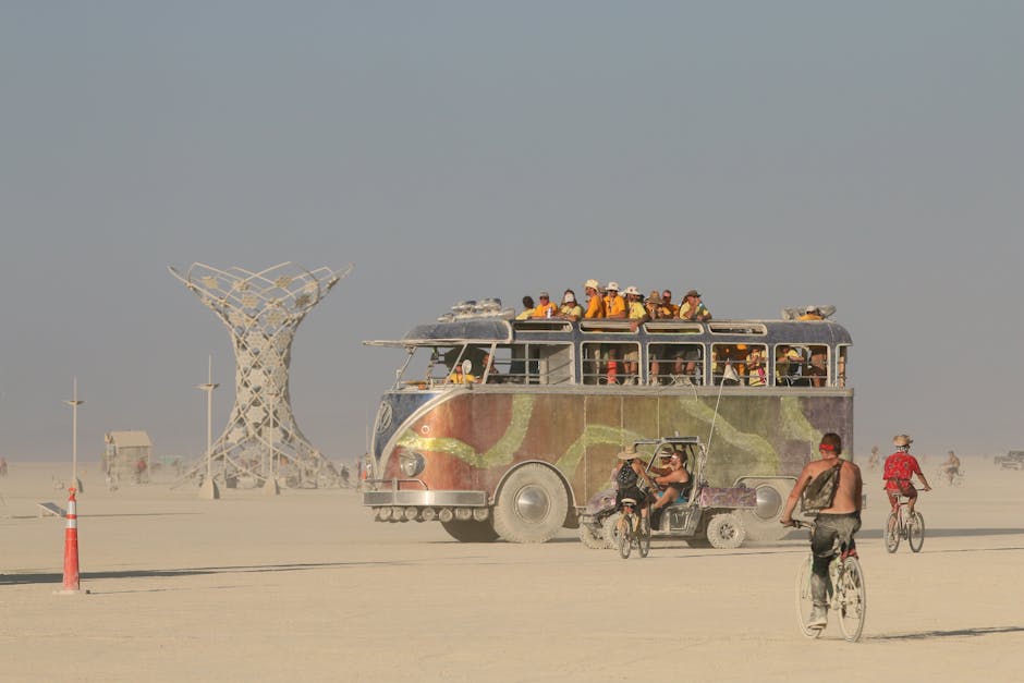 Coinvolgimento comunitario a Burning Man: bus artistico pieno di persone e sculture metalliche nel deserto, esempio di partecipazione attiva