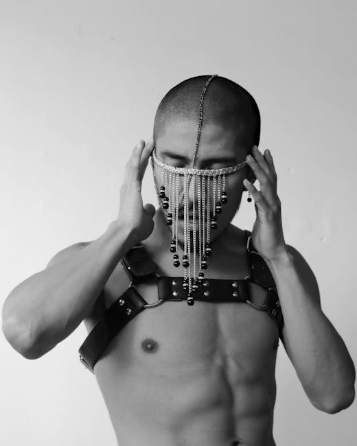 Uomo con imbracatura in pelle e maschera di perline, espressione artistica nel settore della pelletteria MCM Unico.