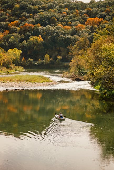 Paesaggio autunnale con fiume e canoa, metafora della navigazione nel mondo della Carta Docente 2025 e delle sue incertezze.