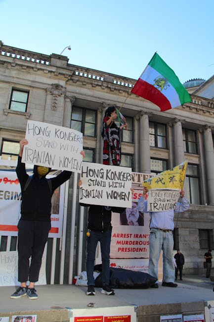 Manifestazione per la democrazia: attivisti con bandiere e cartelli a sostegno delle donne iraniane e di Hong Kong.
