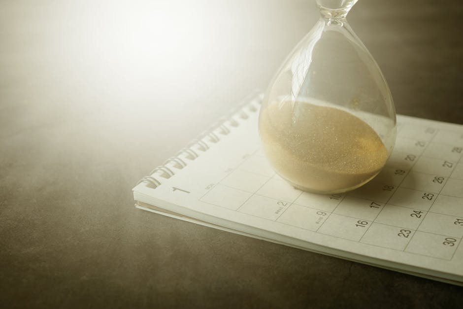 Gestione del tempo: clessidra su calendario per ottimizzare giorni e ore, pianificazione efficace e miglioramento della produttività personale.