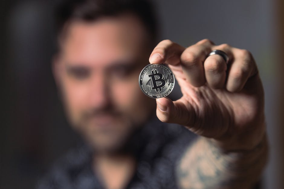 Uomo che mostra una moneta Bitcoin: implicazioni per le scienze attuariali e la previsione del futuro economico