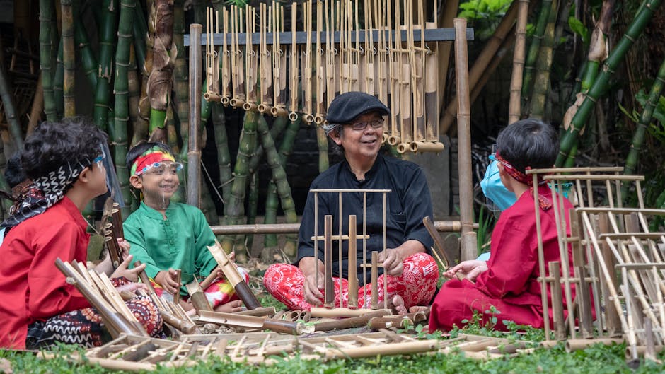 Bambini e insegnante suonano l'angklung, strumento musicale tradizionale, durante un'attività di educazione musicale all'aperto.