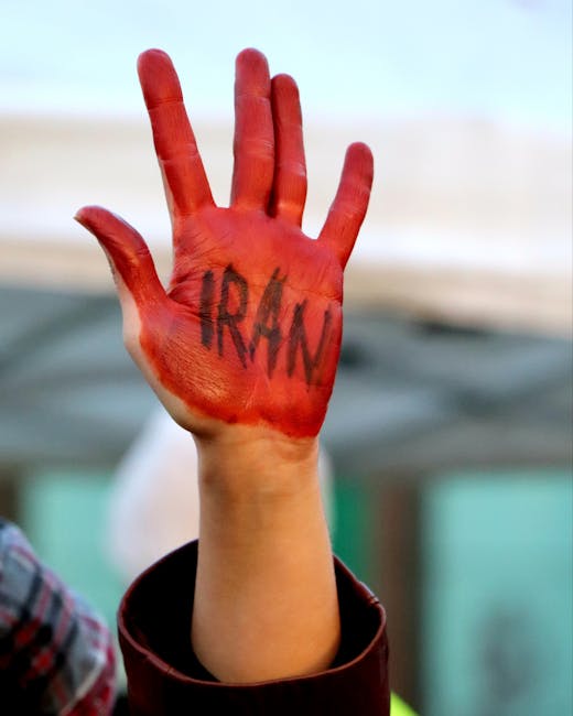 Mano alzata dipinta di rosso con la scritta Iran, simbolo di solidarietà e attenzione verso la situazione iraniana durante l'incontro con Re Carlo III.