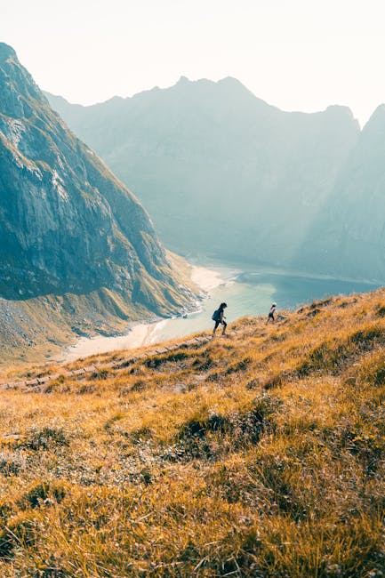 Escursionisti in salita su un sentiero di montagna con vista panoramica sul lago, metafora del percorso di miglioramento personale e crescita interiore.