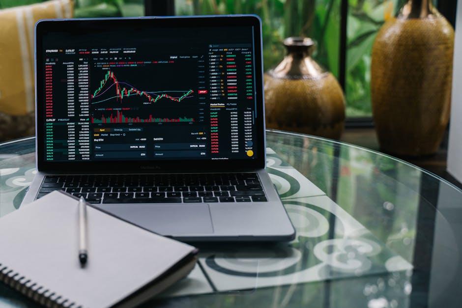 Laptop con grafico di trading online e notebook per investire in sicurezza sulle piattaforme di trading finanziario.