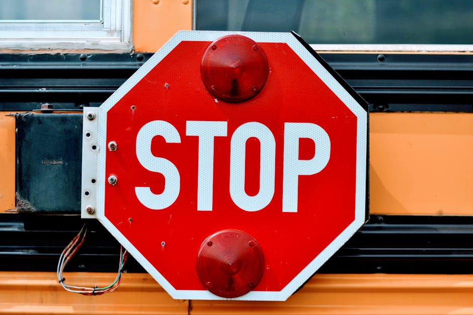 Segnale di stop su scuolabus, simbolo di sicurezza e prevenzione come i metal detector nelle scuole per Valditara.