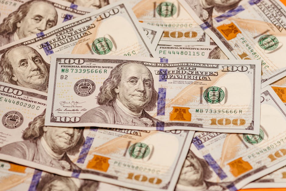 Banconote da 100 dollari USA sparse, simbolo di budget scolastico e gestione finanziaria del patrimonio scolastico