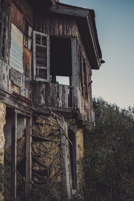 Casa abbandonata con finestre aperte e struttura in legno fatiscente, metafora di abbandono e rinascita, legata ai benefici della musica per i bambini.