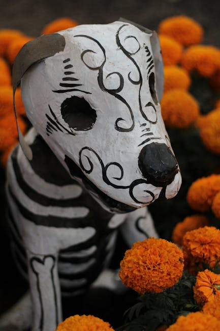 Scultura cane scheletro Dia de los Muertos circondato da fiori arancioni, simbolo di memoria e ricordo dei defunti.