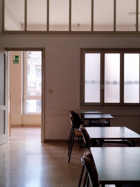 Aula scolastica a Milano con banchi e finestra: incidente in una scuola milanese, ferito studente per cedimento finestra
