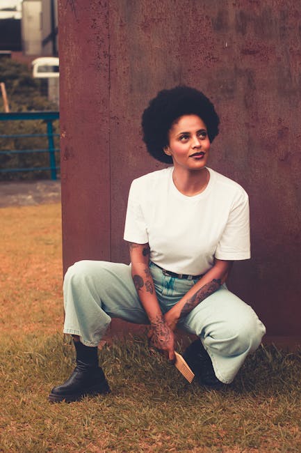Donna afroamericana con pettine afro seduta sull'erba: esempio di diversità e inclusione nel curriculum vitae.