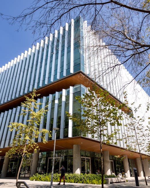 Edificio moderno con vetrate e alberi, simbolo di opportunità per laureandi in Inglese e sviluppo professionale