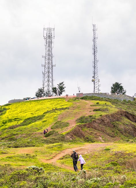 Persone che camminano verso le torri di comunicazione: esempio di interazione e trasmissione di messaggi non verbali in ambiente naturale.