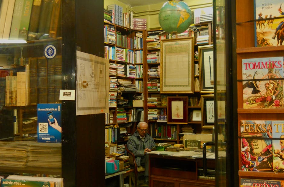 Libreria antica con uomo seduto alla scrivania circondato da libri e un globo, ideale per un anno all'estero con Intercultura.