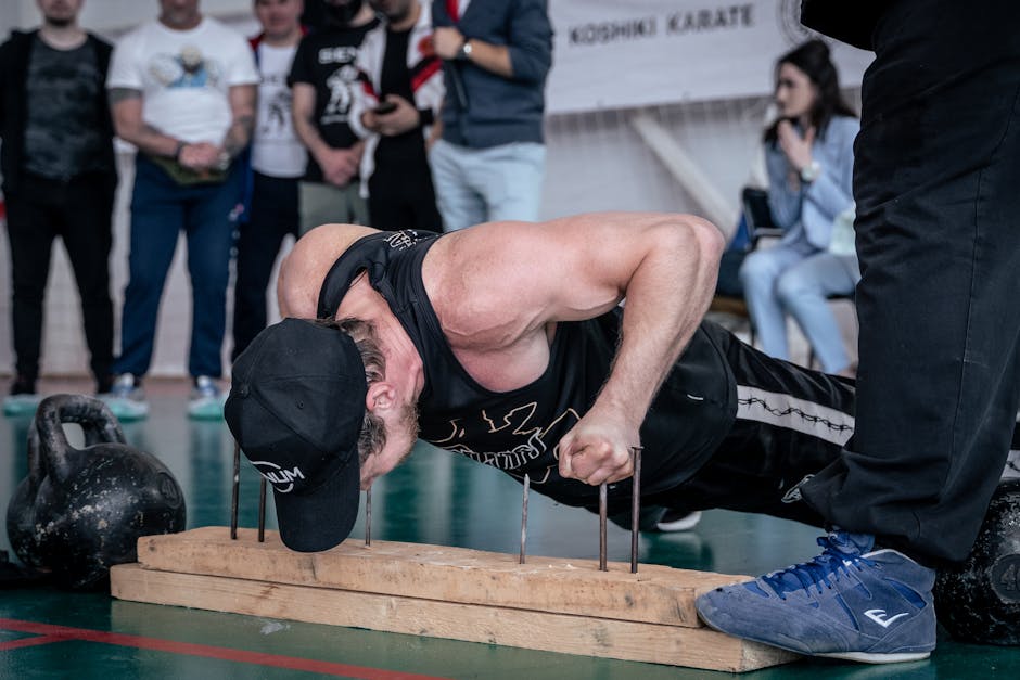 Uomo muscoloso esegue flessioni sui chiodi dimostrando forza e controllo, un'attività che brucia calorie e favorisce la forma fisica.