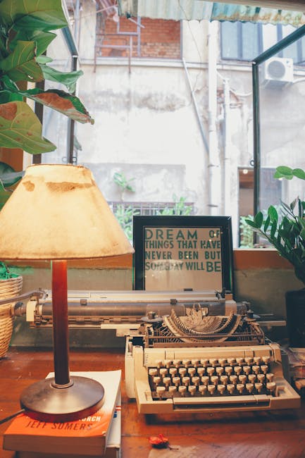 Macchina da scrivere vintage e lampada su scrivania, elementi evocativi per lo studio della letteratura comparata e l'analisi testuale.