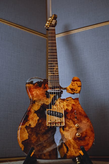 Chitarra elettrica unica con corpo in legno pregiato e finiture dorate, strumento musicale di alta liuteria per suono distintivo.