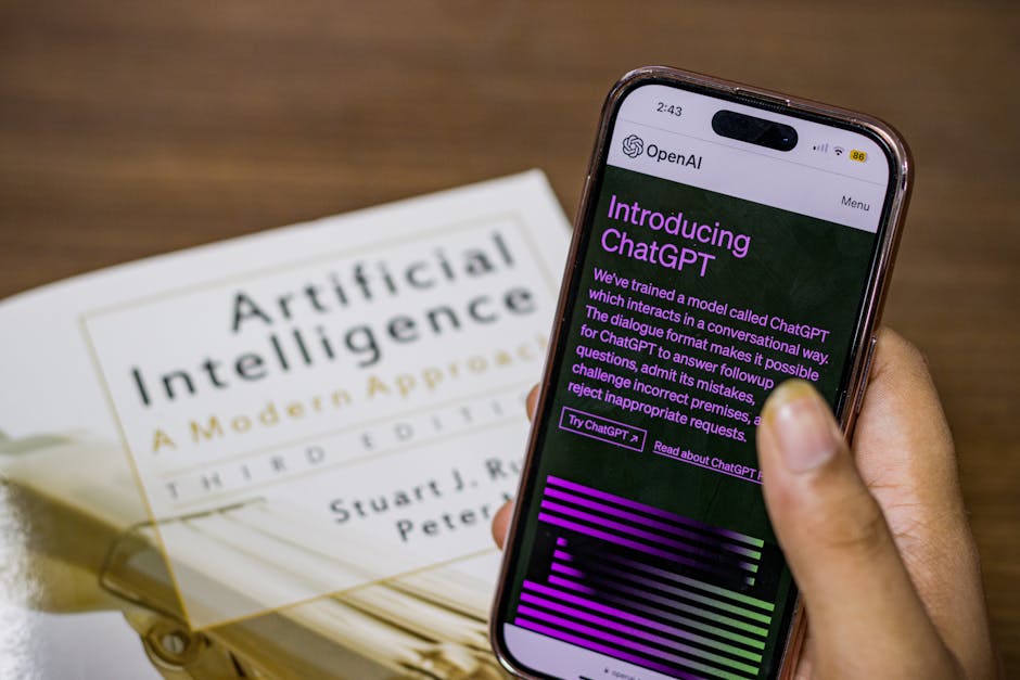 ChatGPT su smartphone accanto a libro Intelligenza Artificiale: OpenAI e finanziamenti per la rivoluzione AI