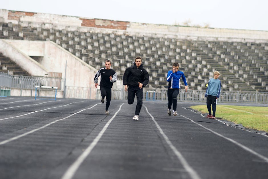 Giovani atleti corrono su pista di atletica, metafora per affrontare le sfide della salute mentale giovanile e promuovere il benessere.