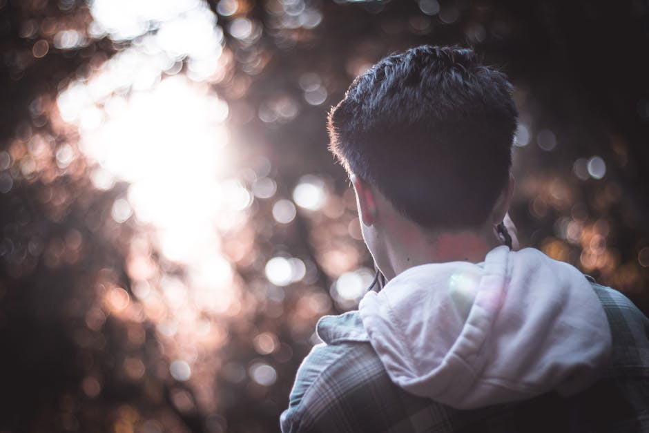 Ragazzo di spalle immerso nella luce, metafora della scoperta nei laboratori di fotografia e della creatività visiva.