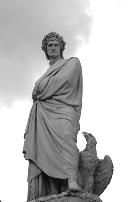 Statua in bianco e nero di Dante Alighieri con corona d'alloro e aquila, simbolo del suo impatto sulla cultura italiana.