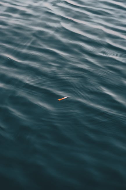 Mozzicone di sigaretta galleggiante nell'acqua: immagine simbolica dell'impatto ambientale delle nostre azioni e delle loro conseguenze sull'ecosistema marino.